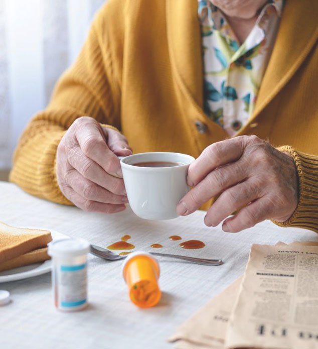 Лечение болезни Паркинсона Пожилая женщина с болезнью Паркинсона пьет чай