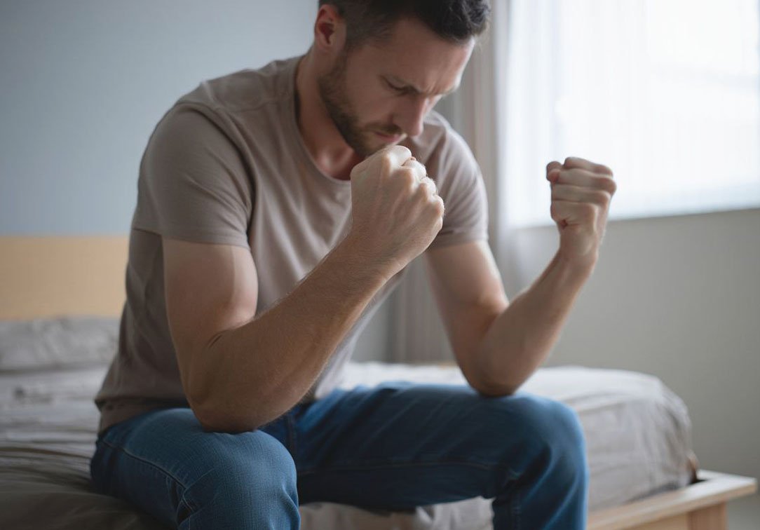 Лечение психопатии Мужчина злится сидя на кровати